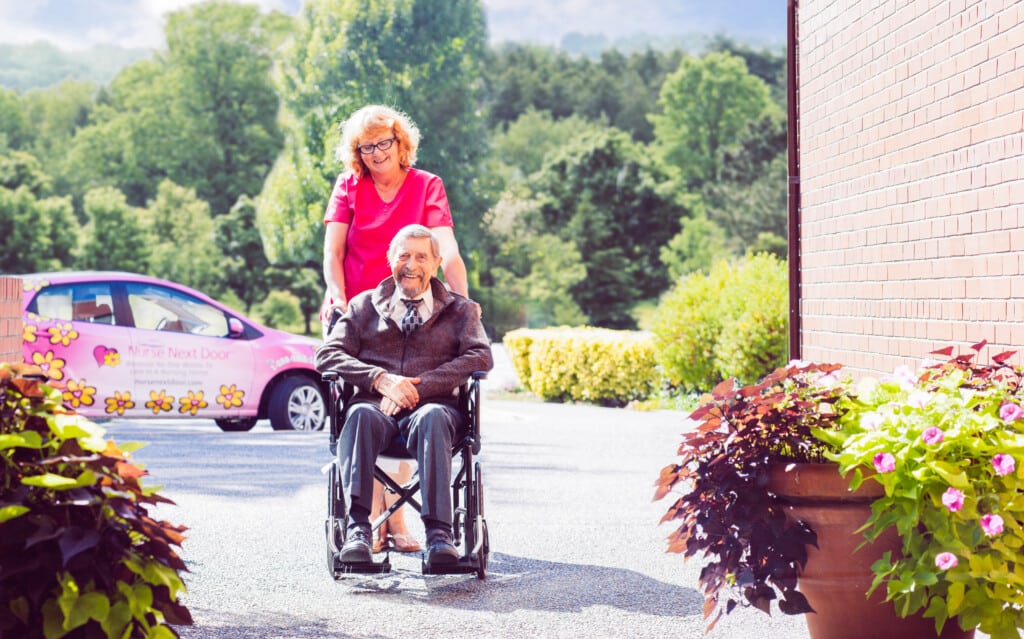 A Nurse Next Door caregiver assisting a veteran in a wheel chair